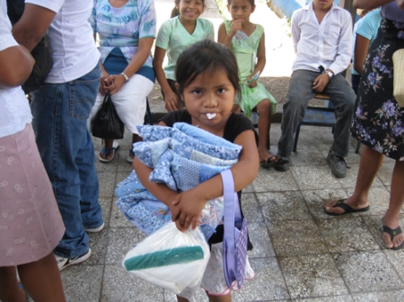 Guatemalan girl with blanket, hygiene kit and cotton roll after an extraction